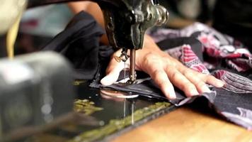 A man is sewing a customer's order video