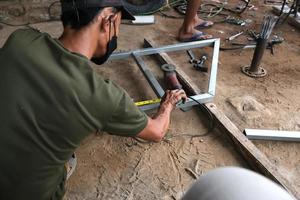 un hombre trabaja como soldador en un taller de reparación local