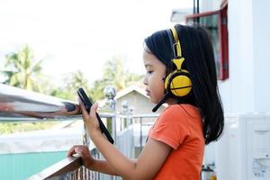 niñita asiática con auriculares con videollamada, jovencita feliz videollamada con amigos