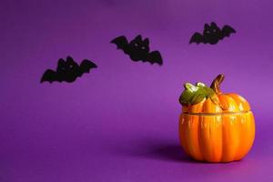 Halloween backgrounds of white, orange and gold pumpkins, spiders and black bats on a purple background with cobwebs and terrible scenery. Horror and a scary holiday with copy space photo