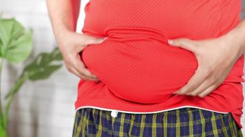 La mano del hombre sujetando el exceso de grasa abdominal, concepto de sobrepeso video