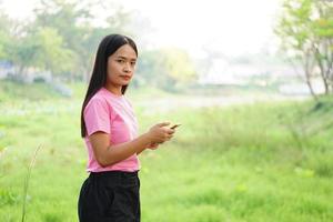 Asian woman using phone in park photo