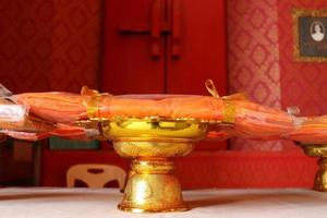 Set of monk's robes on golden tray and red blur background, Thailand. photo