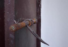 A dark brown painted door lock made from iron in ancient style, Thailand. Rusty on surface of door lock. photo