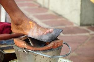 Iron plow plate is on clay fire pot and blur foot with above plow plate. Preparation equipment set for Thai massage in Northern style. photo