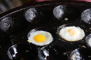 Quail eggs are grilling on Kanom Krok pan, Thailand. photo