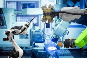 automatización industrial robótica de agarre y robot de soldadura trabajando con metal en fábrica inteligente foto