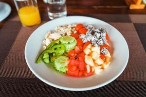 desayuno de ensalada de frutas y fruta en el plato foto