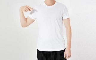 hombre de cerca señaló en maqueta de camiseta blanca en blanco vacía foto