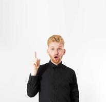 Portrait of happy young red hair man pointing with finger up on empty background copy space photo