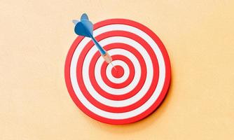 Dartboard and dart on center of target on yellow background. Business success and strategy concept. 3D illustration rendering photo
