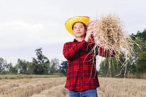 granjero asiático con rastrojo de arroz en el campo foto