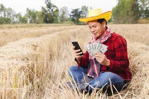 granjero asiático con rastrojo de arroz en el campo foto