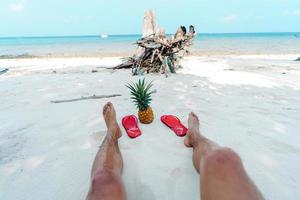 Summer beach vacation with pineapples and flip flops on the beach photo
