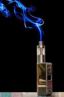 3D electronic cigarette and smoke on the table rock on a black background. photo