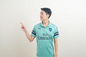 Bangkok, THAILAND - Nov 27, 2021 - Young Asian man wearing Arsenal shirt with white background. photo