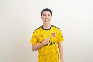 Bangkok, THAILAND - Nov 27, 2021 - Young Asian man wearing Arsenal shirt with white background. photo