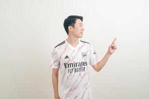 Bangkok, Tailandia - 27 de noviembre de 2021 - joven asiático vistiendo la camiseta del arsenal con fondo blanco. foto