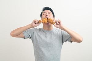 young Asian man with fried chicken on hand photo