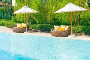 outdoor patio chair with pillow and umbrella around swimming pool