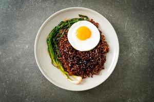 dried Korean spicy black sauce instant noodles with fried egg and kimchi