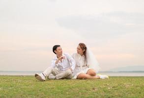 Happy young Asian couple in bride and groom clothing photo