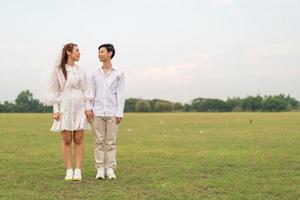 Happy young Asian couple in bride and groom clothing photo