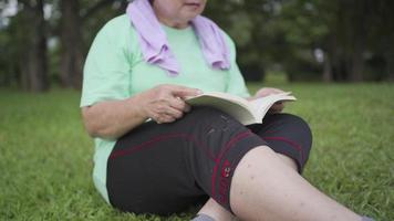 mulher idosa asiática sente-se lendo livro no parque após o exercício, atividade de lazer na velhice no tempo livre, vida de aposentadoria bem-estar vitalidade relaxamento, verme de livro leitor analógico feminino idoso, tempo livre