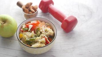 Fitness concept with dumbbell, fresh vegetable, almond nut and apple on table video