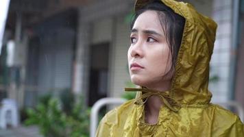 young beautiful asian female wear yellow hoody raincoat feeling sad and disappoint in the pouring rain day, rainy season weather climate, feeling blue and lonely, Bad stormy sorrow unhappy vibe video