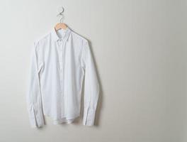 hanging shirt with wood hanger on wall photo