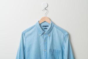 hanging shirt with wood hanger on wall photo