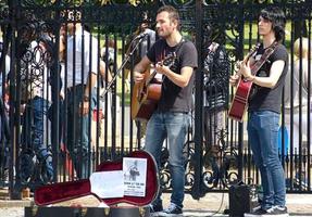 Greenwich, London, England, July 1, 2014, Young street performers playing acoustic music with guitars in the historic downtown district of Greenwich. Busking on street concept. England.