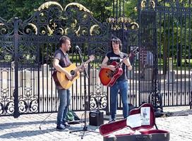 Greenwich, London, England, July 1, 2014, Young street performers playing acoustic music with guitars in the historic downtown district of Greenwich. Busking on street concept. England.