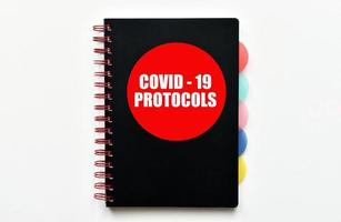 protocolos covid-19. manual con protocolos covid-19 aislado sobre fondo blanco. foto