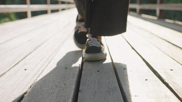 feche os tênis modernos andando na ponte, caminho de ângulo baixo, saindo do início do novo capítulo, saia da zona de conforto, passos de sapatos com sombra em dia ensolarado, atividades de recreação video