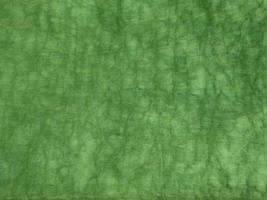 Surface texture of green color and crumpled canvas fabric photo