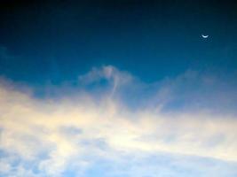 Crescent moon and clouds in the sky photo