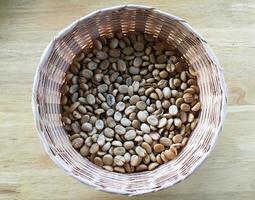 grano de café asiático orgánico en cesta de mimbre. foto
