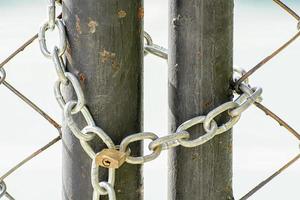 A lock and chain on Metal Fence that links of a gate. photo