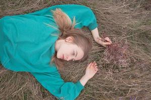 Young woman in fields, portrait of beautiful female relaxing in dry grass photo