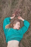 Young woman in fields, portrait of beautiful female relaxing in dry grass photo