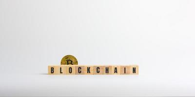 tecnología blockchain y concepto de criptomoneda. bitcoin dorado con el texto de blockchain y bloque de madera de cubo. billetera y financiera digital, dinero descentralizado y datos de transacciones. foto