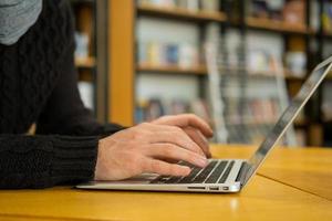 Handsome male read book and work in modern library photo