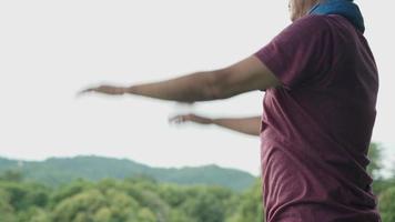 homem asiático fazendo exercício de balanço de braços em pé para aquecer no parque, braços de aventura de nova vida, alongamento completo, cuidados de saúde, seção do meio do corpo, exercício básico simples e fácil para iniciantes, dieta para perder peso video