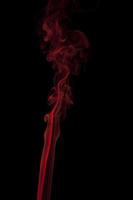 Red smoke swirling on a black background photo