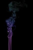 humo púrpura arremolinándose sobre un fondo negro foto
