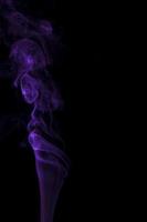 Purple smoke swirling on a black background photo