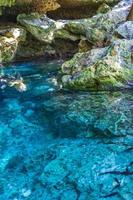 Blue turquoise water limestone cave sinkhole cenote Tajma ha Mexico. photo
