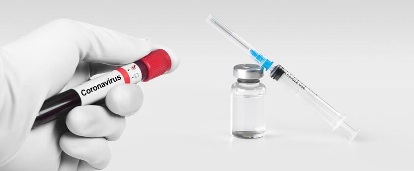 mano sosteniendo viola con muestra de sangre de coronavirus 2019-ncov. jeringa médica y bollte con vacuna en el fondo. foto